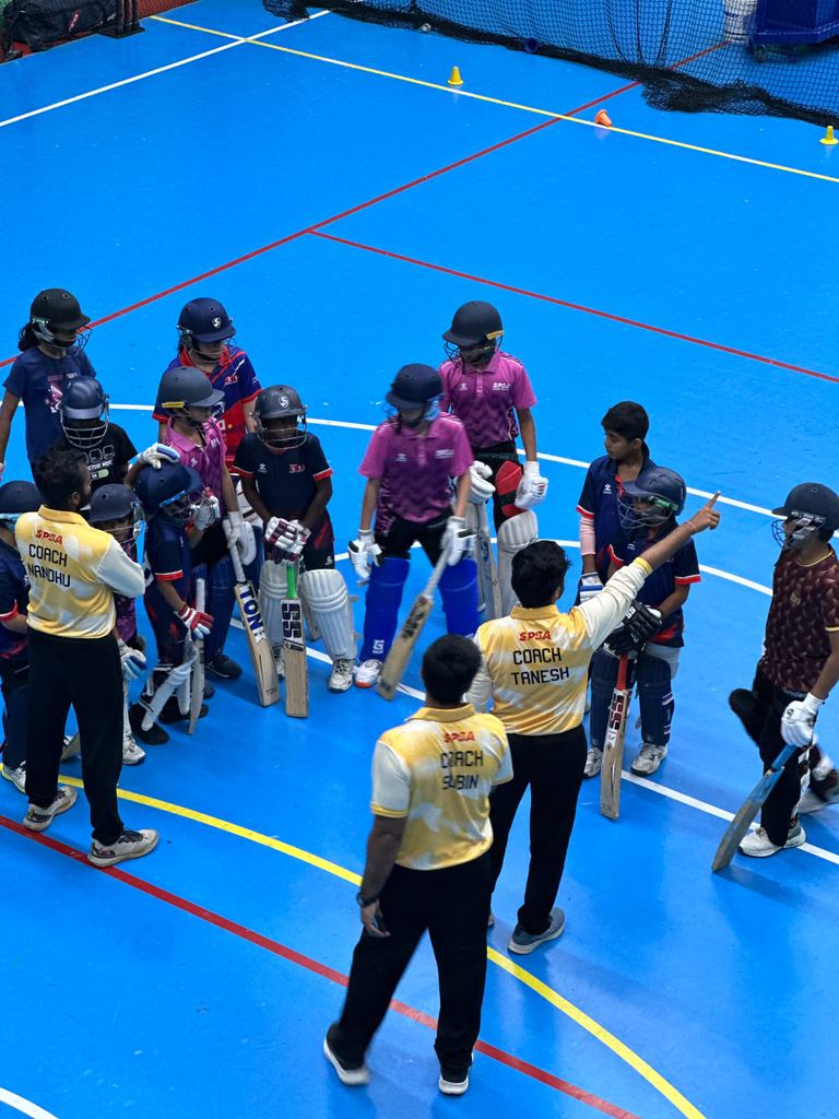 SPSA coaches briefing padded-up junior cricketers before an indoor session at Dubai Investments Park