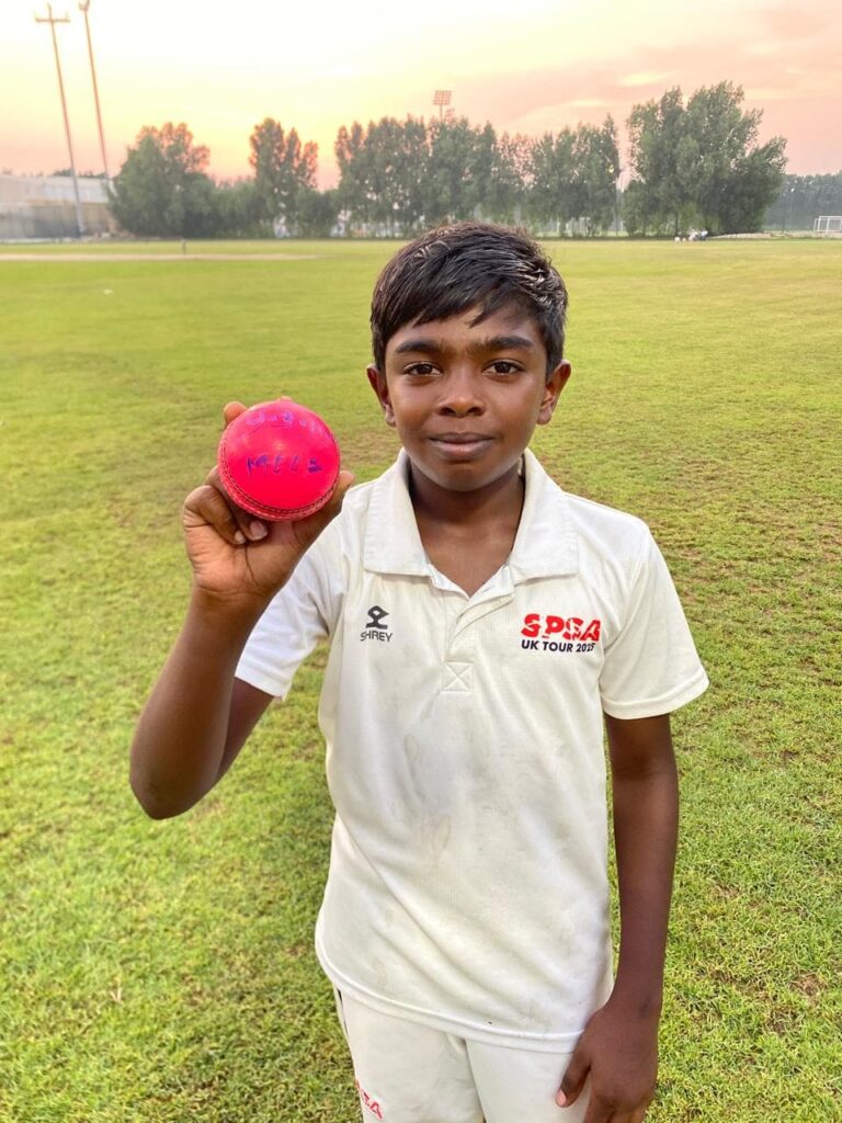 Young SPSA bowler holding up the pink ball at sunset after a five-wicket haul